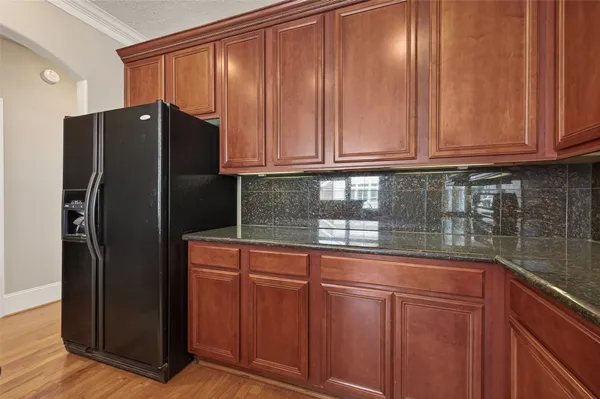 a kitchen with stainless steel appliances granite countertop wood cabinets and refrigerator
