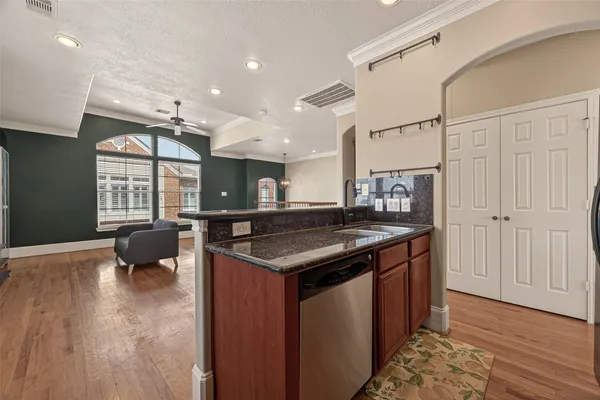 a kitchen with a stove and a wooden floor
