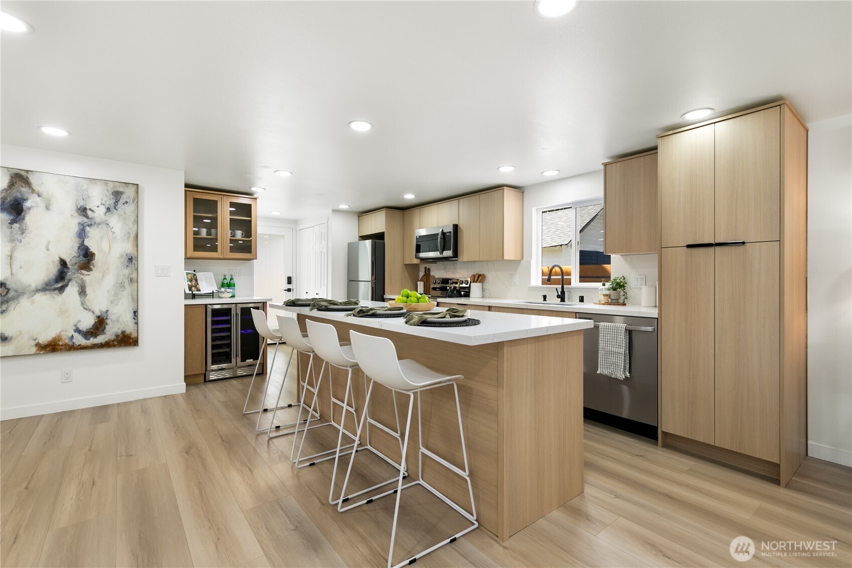 11 Southwest 100th Street Seattle, WA 98146 - Photo 11 of 36 a kitchen with stainless steel appliances a refrigerator a stove a sink dishwasher and white cabinets with wooden floor