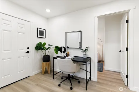 a view of a workspace room with wooden floor table and chair