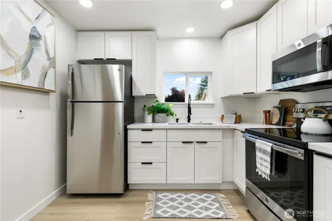 a kitchen with white cabinets and stainless steel appliances