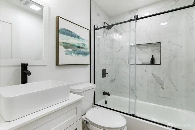 a bathroom with a shower a toilet and a sink