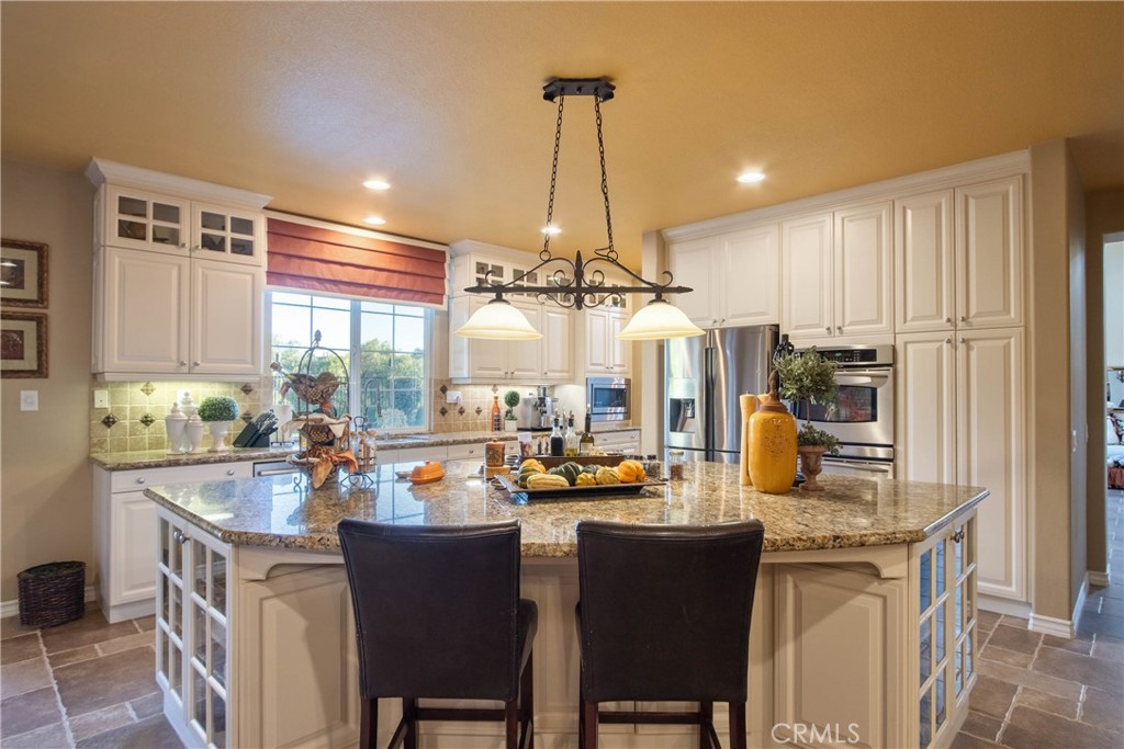 32815 Cleveland Street Temecula, CA 92592 - Photo 16 of 71 a kitchen with a refrigerator a stove and a dining table with wooden floor