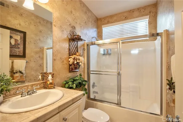 a white toilet sitting next to a bathroom sink