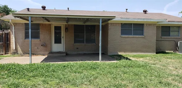 a view of a house with potted plants and a yard