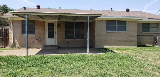 a view of a house with potted plants and a yard