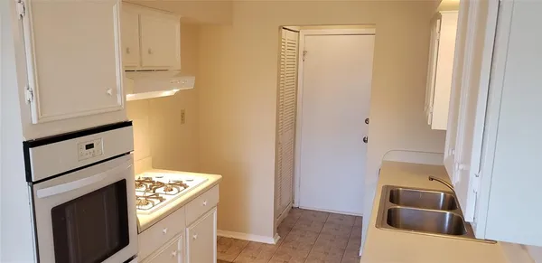 a kitchen with a sink and a stove top oven