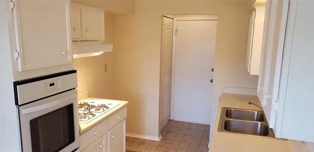 a kitchen with a sink and a stove top oven