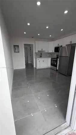 a view of kitchen with stainless steel appliances a sink and a refrigerator