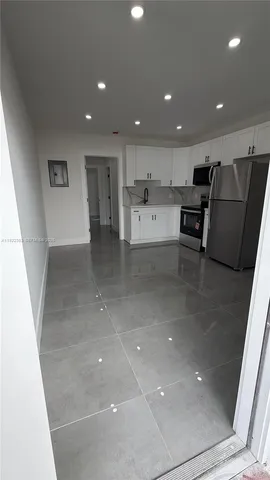 a view of kitchen with stainless steel appliances a sink and a refrigerator