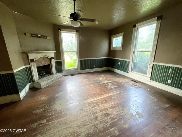 a view of an empty room with window and fire place