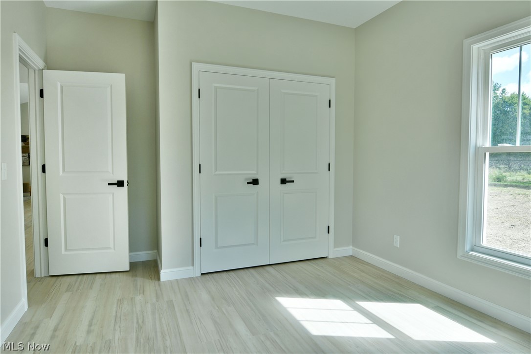 4780 State Rte 5 Cortland, OH 44410 - Photo 30 of 50 Light-toned wood-finish flooring, white trim, and a white window frame with multiple panes