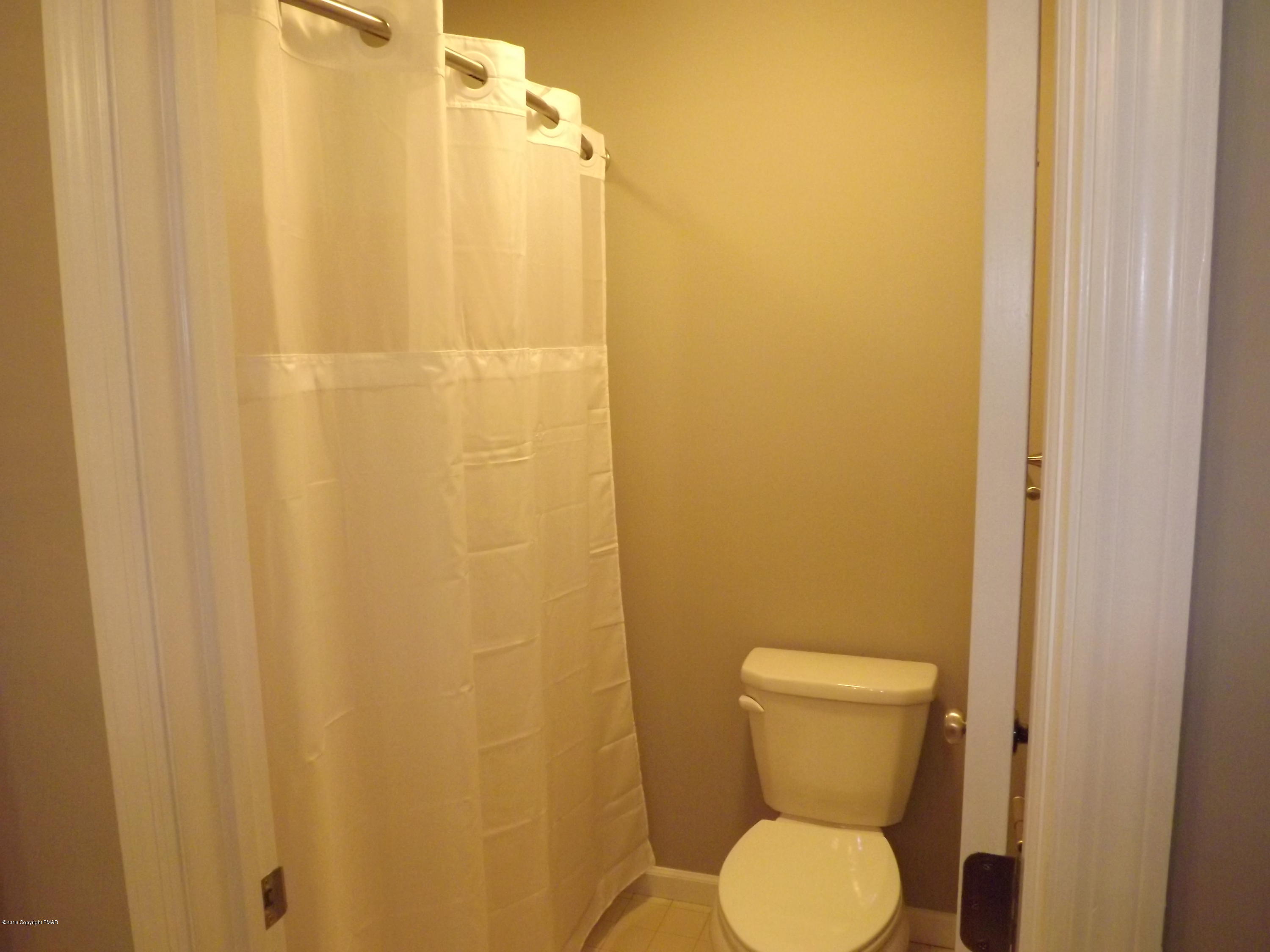 2111 Fox Run Road Stroudsburg, PA 18360 - Photo 59 of 72 a toilet sitting in a bathroom next to a shower curtain