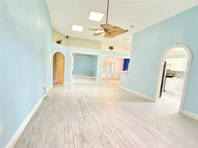 a view of a room with wooden floor and a ceiling fan