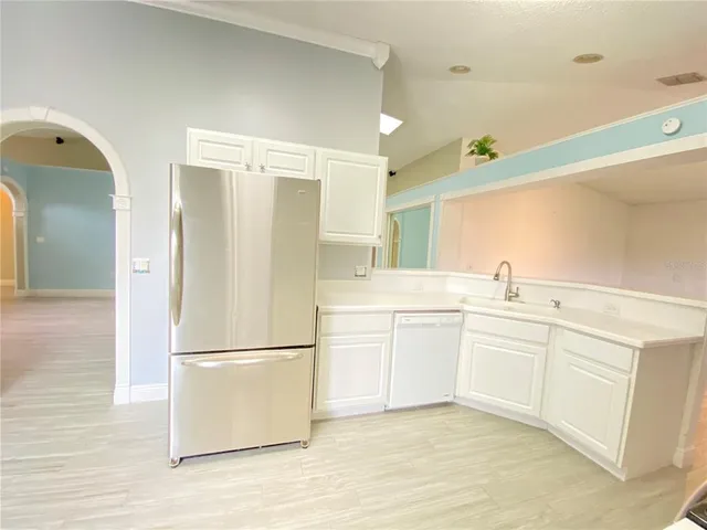 a kitchen with white cabinets and white appliances