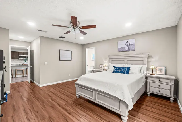 a living room with furniture and a dining table with wooden floor
