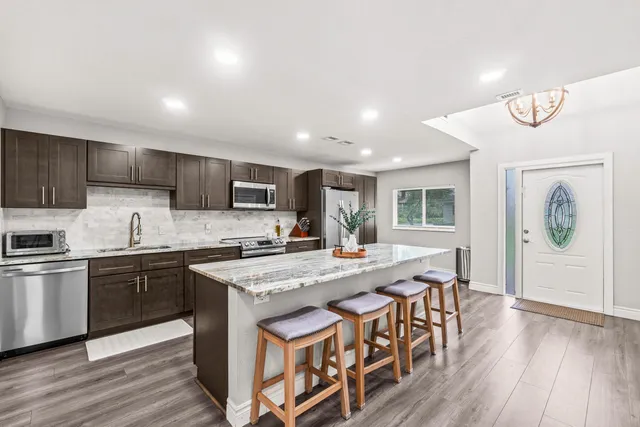 a living room with furniture flat screen tv and a large window