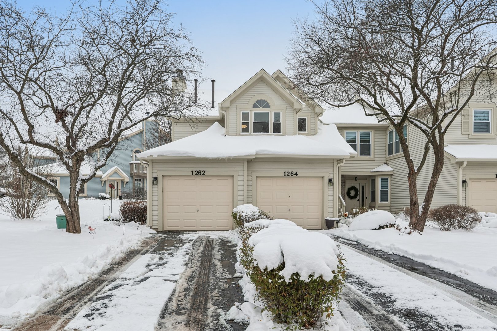 a front view of a house with a yard covered in snow