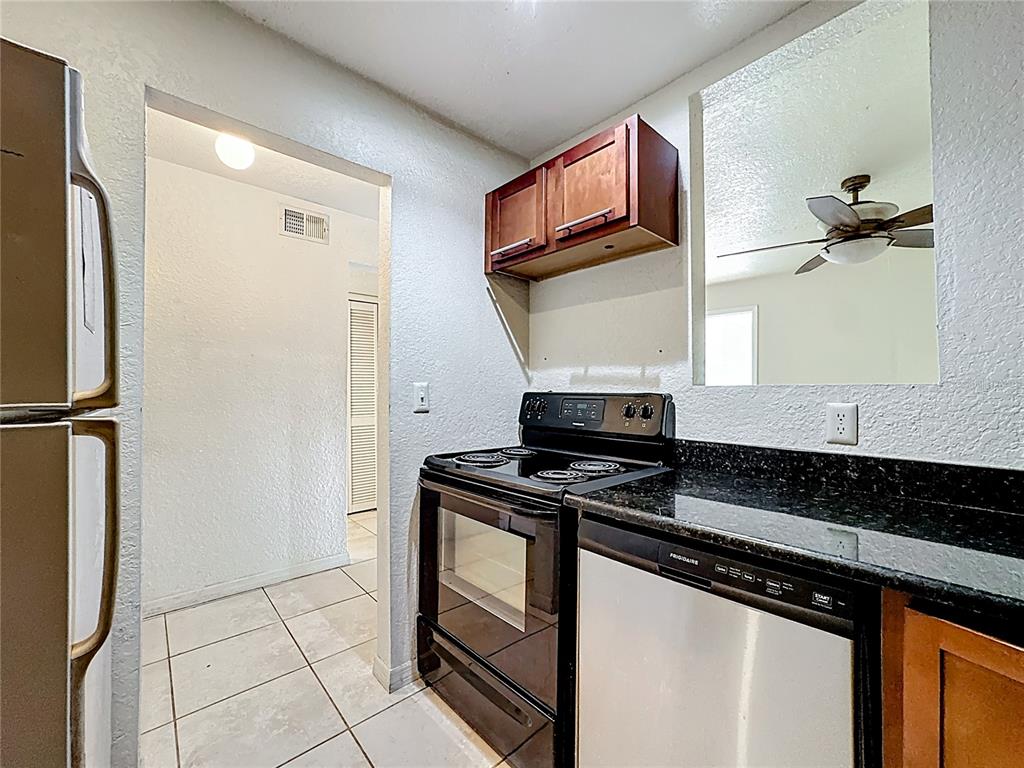 1928 South Conway Road, Unit 33 Orlando, FL 32812 - Photo 14 of 34 a kitchen with stainless steel appliances granite countertop a stove and a refrigerator