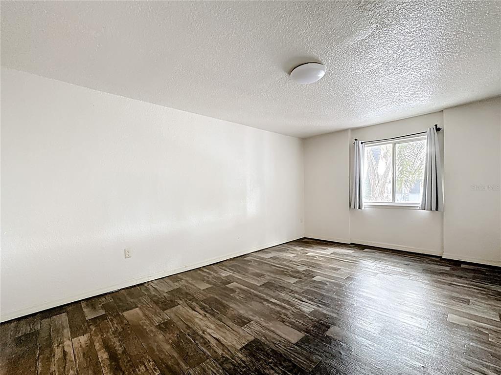 1928 South Conway Road, Unit 33 Orlando, FL 32812 - Photo 24 of 34 an empty room with wooden floor and windows