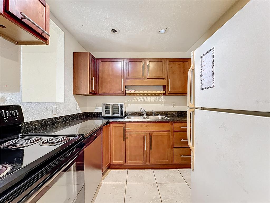 1928 South Conway Road, Unit 33 Orlando, FL 32812 - Photo 9 of 34 a kitchen with stainless steel appliances granite countertop a stove a refrigerator and a sink