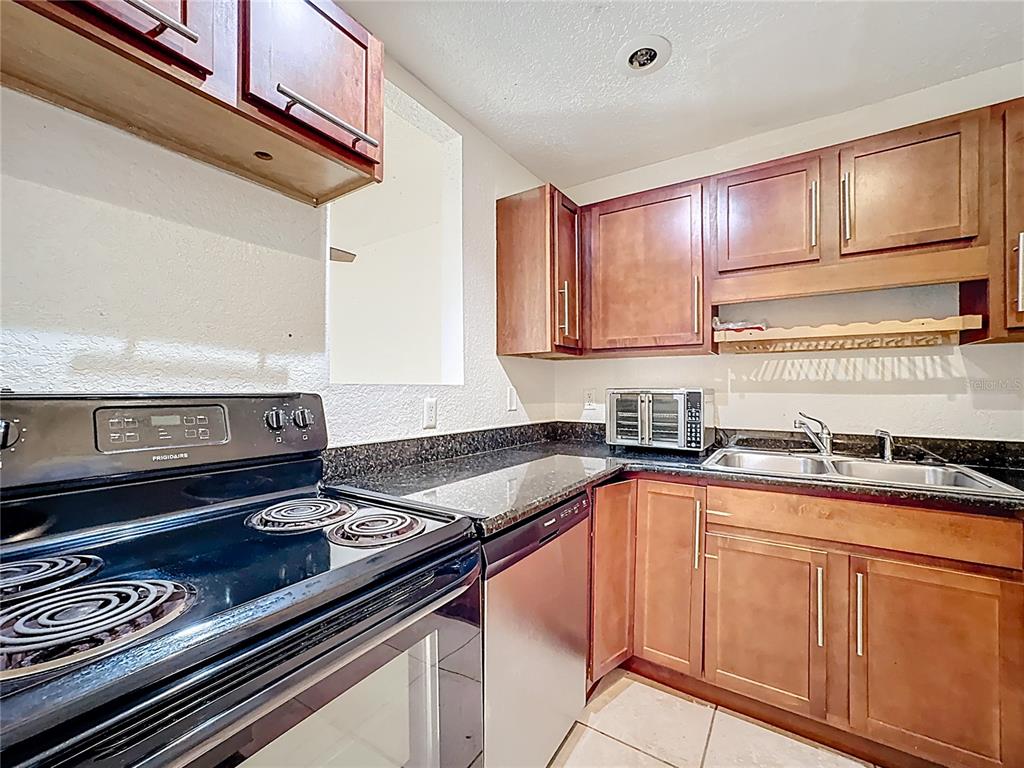 1928 South Conway Road, Unit 33 Orlando, FL 32812 - Photo 10 of 34 a kitchen with granite countertop cabinets stainless steel appliances and a sink