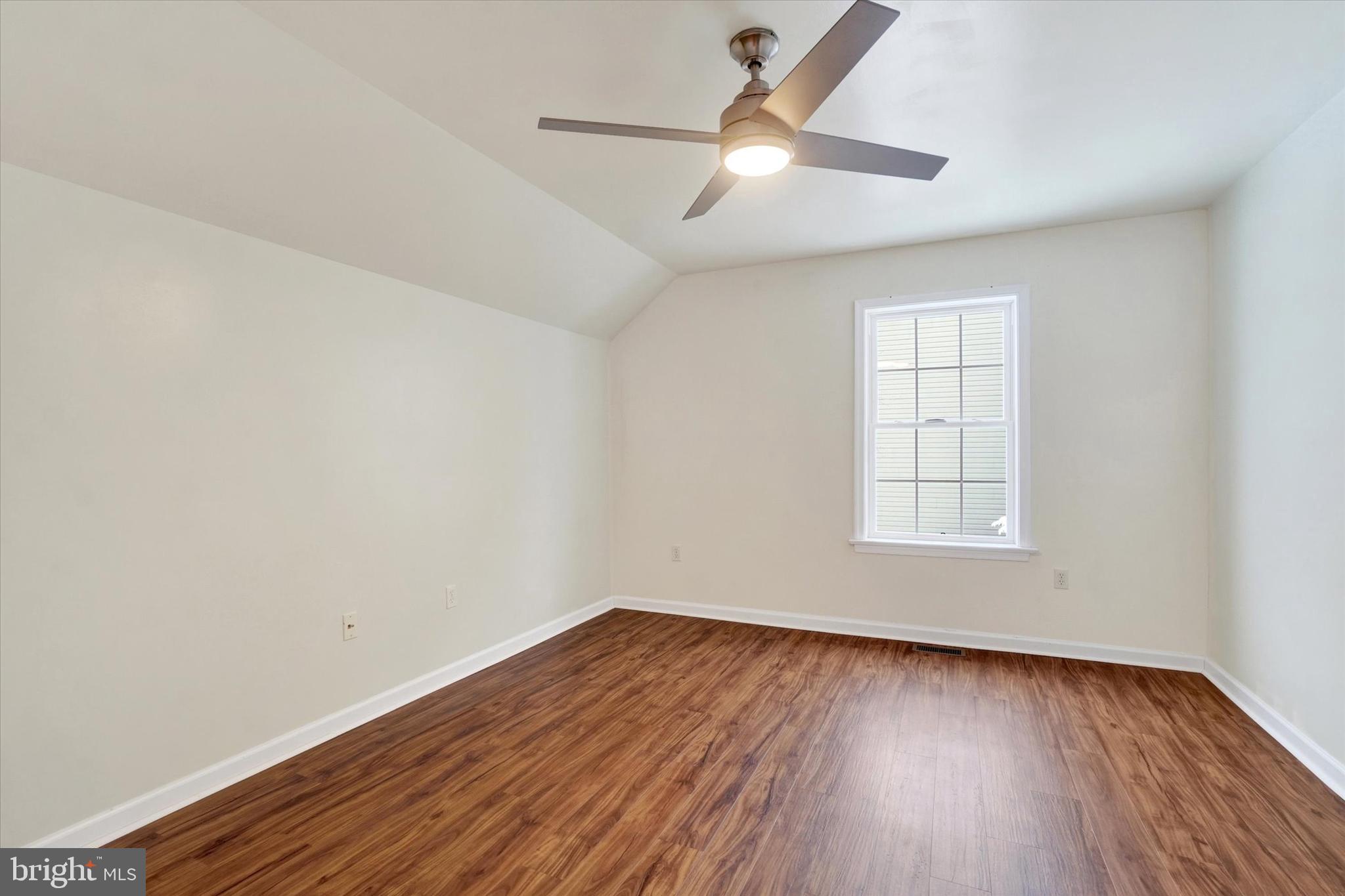 595 Apple Tree Lane Mount Wolf, PA 17347 - Photo 17 of 27 an empty room with wooden floor chandelier fan and windows