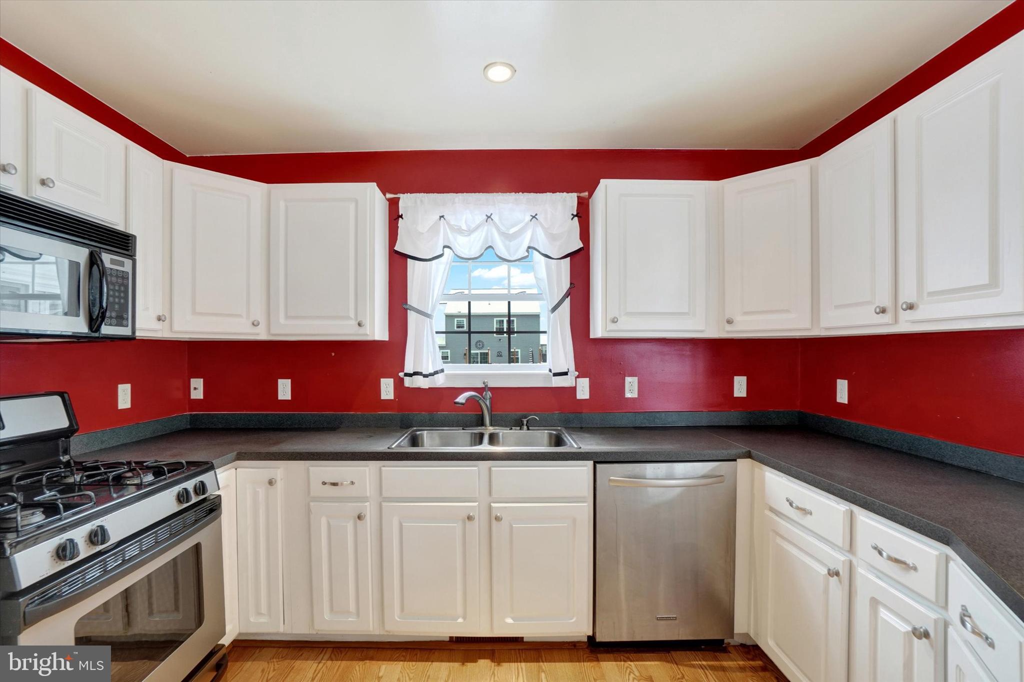 595 Apple Tree Lane Mount Wolf, PA 17347 - Photo 10 of 27 a kitchen with granite countertop a stove a sink dishwasher and cabinets
