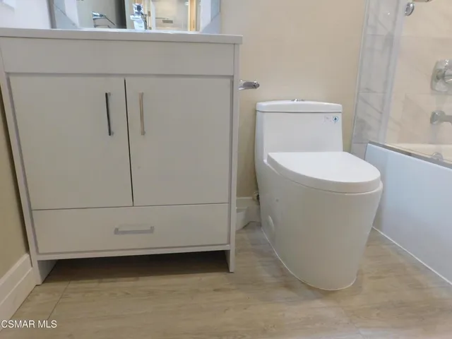a white toilet sitting next to a shower