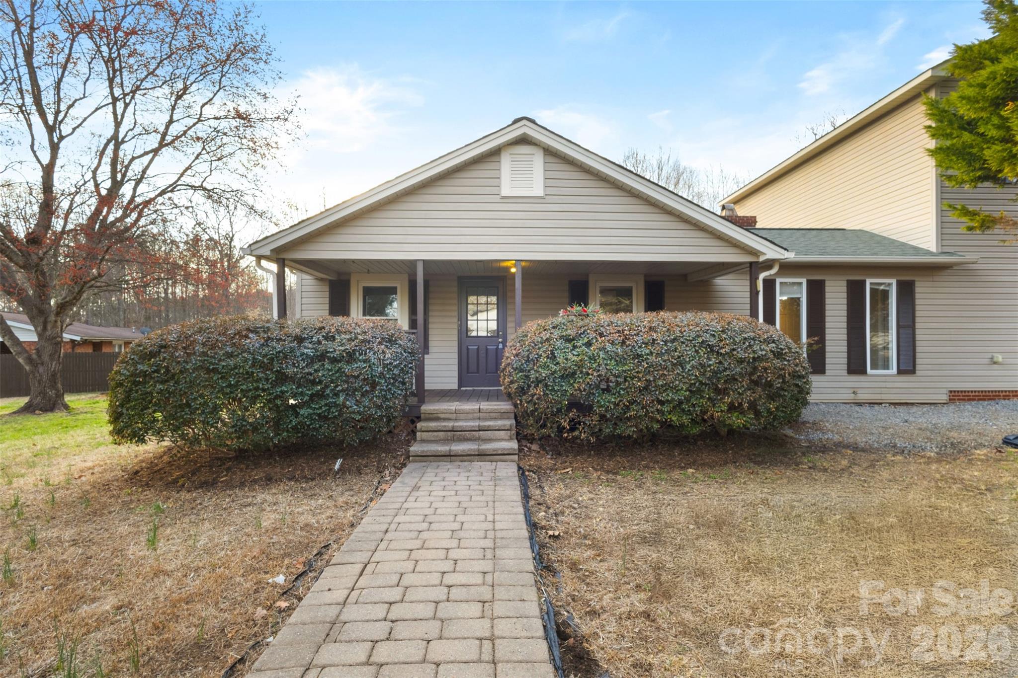 a view of a house with a yard and potted plants
