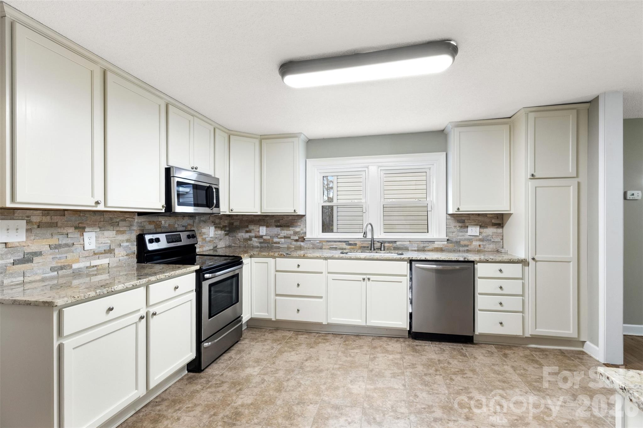 1751 Robert Martin Road Catawba, NC 28609 - Photo 21 of 29 a kitchen with granite countertop a sink stove top oven and cabinets