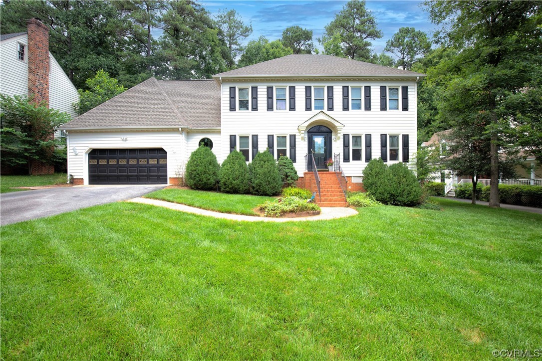 a front view of a house with a garden and yard