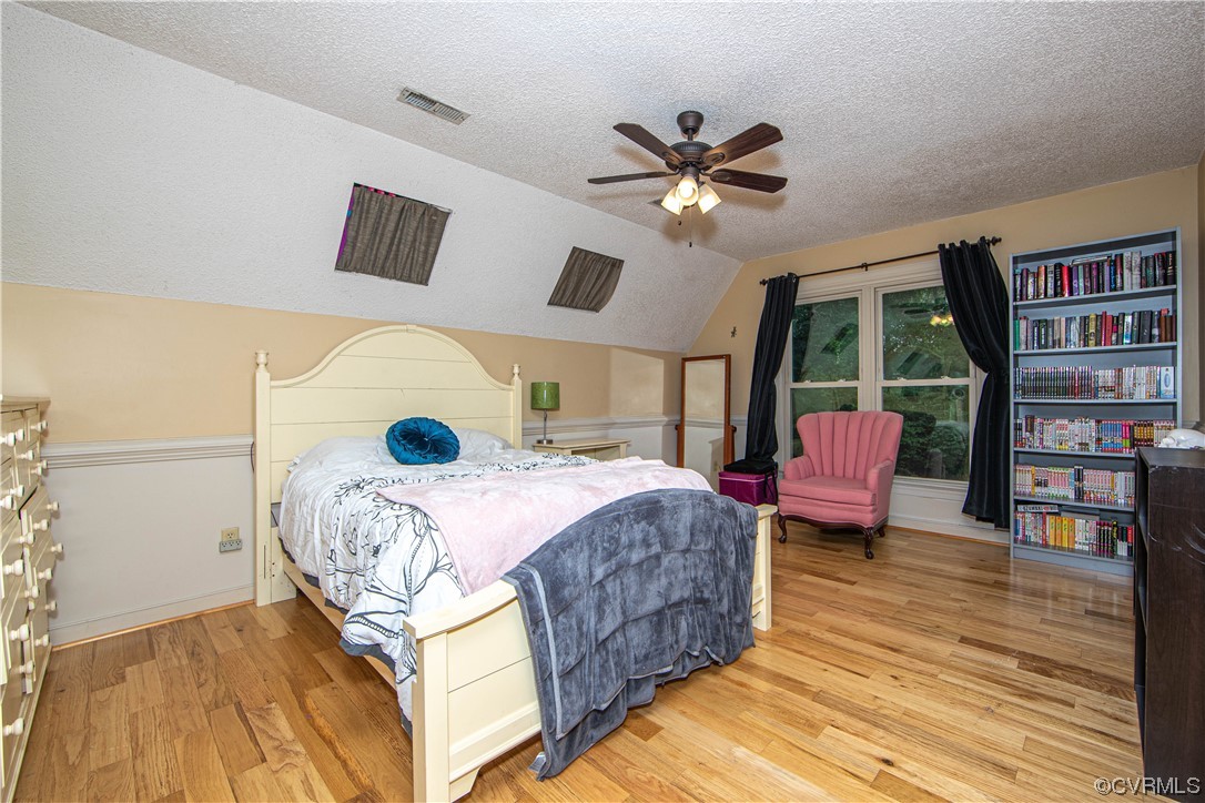 14908 Walnut Bend Road Midlothian, VA 23112 - Photo 26 of 43 a bedroom with a bed a bookshelf and a potted plant