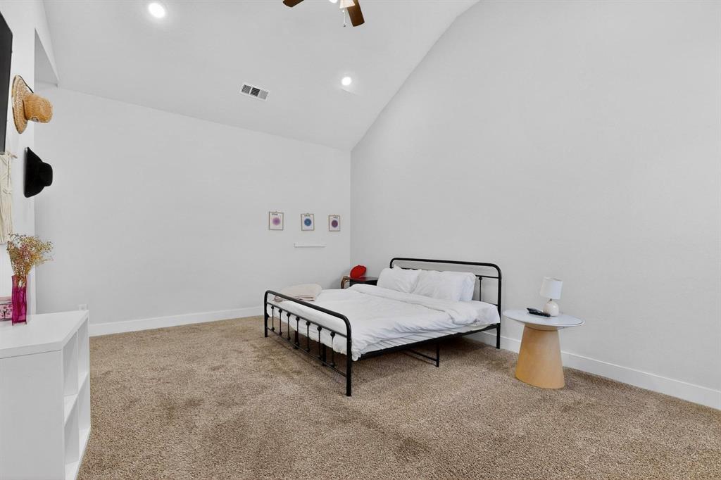 2015 Volga Avenue Dallas, TX 75216 - Photo 21 of 38 Bedroom with light carpet, vaulted ceiling, a ceiling fan, and recessed lighting