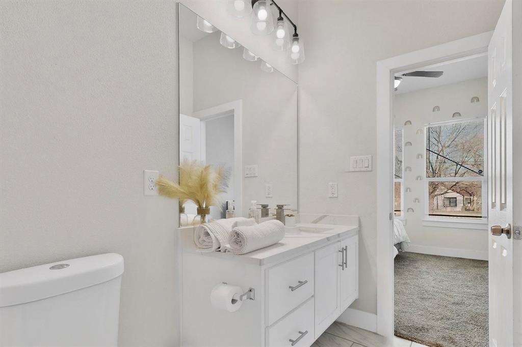2015 Volga Avenue Dallas, TX 75216 - Photo 25 of 38 Bathroom featuring vanity, light colored carpet, and ensuite bathroom