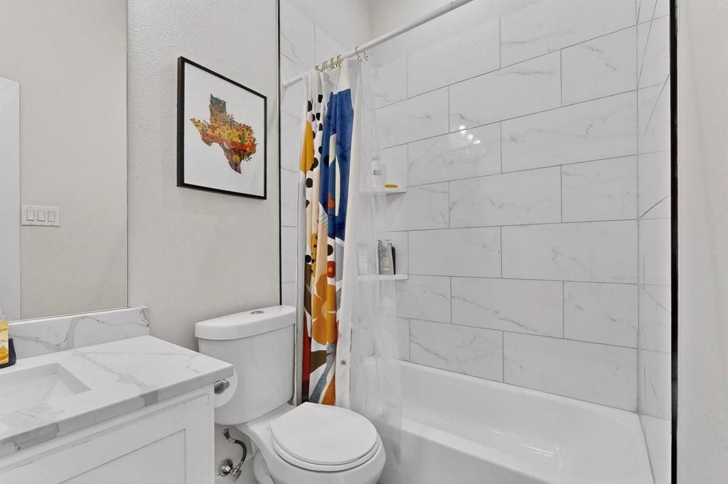 2015 Volga Avenue Dallas, TX 75216 - Photo 29 of 38 Bathroom with shower / bathtub combination with curtain and vanity