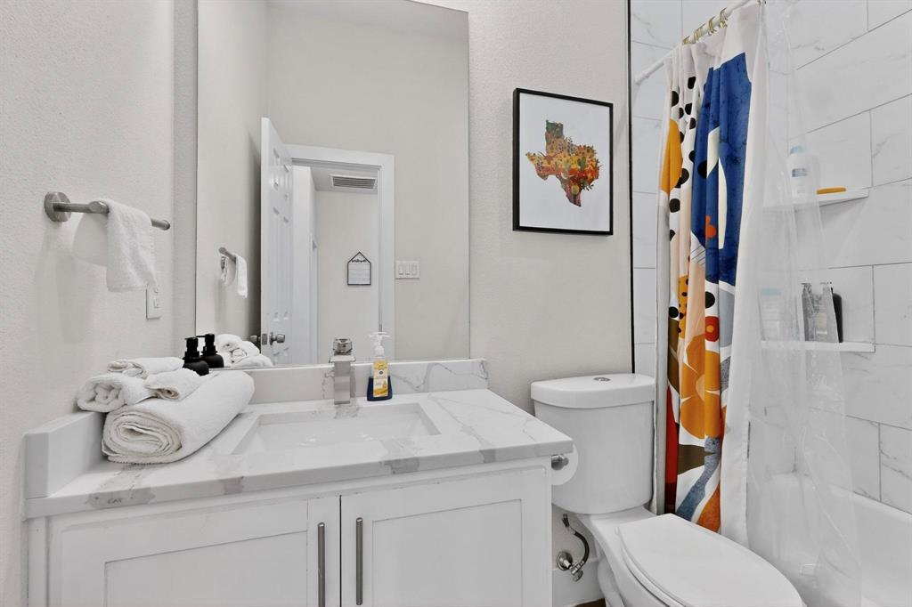 2015 Volga Avenue Dallas, TX 75216 - Photo 31 of 38 Bathroom with shower / bathtub combination with curtain and vanity