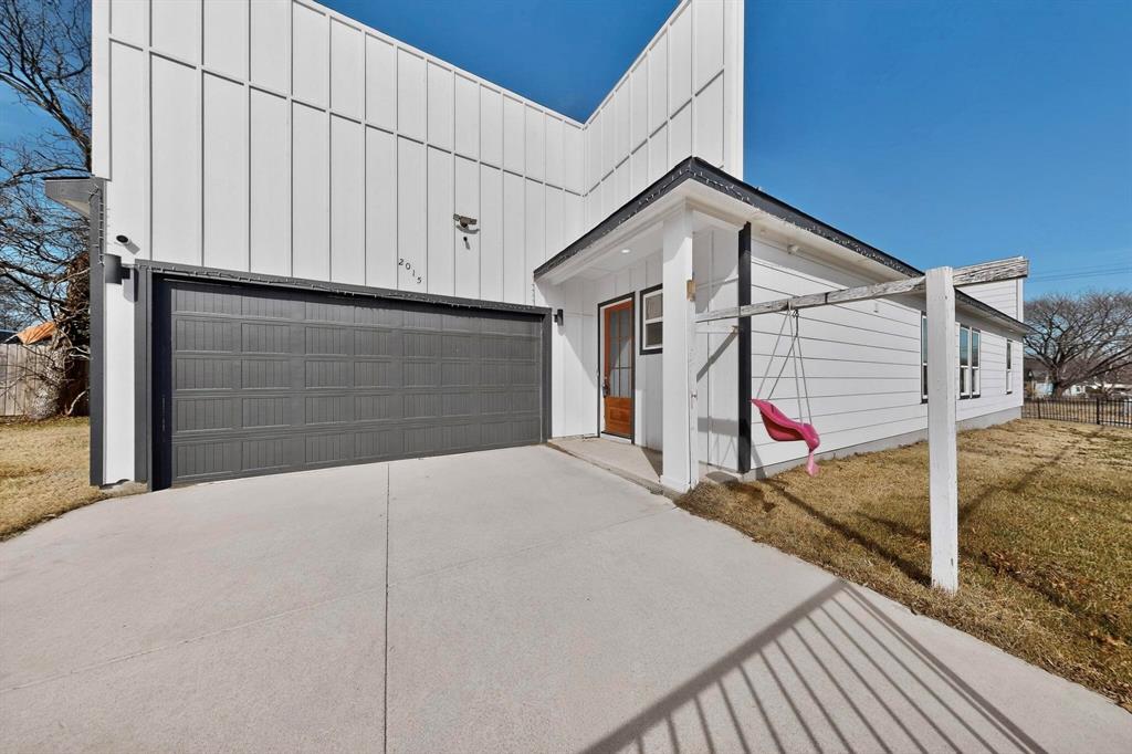 2015 Volga Avenue Dallas, TX 75216 - Photo 8 of 38 View of front of house with board and batten siding, driveway, and a garage