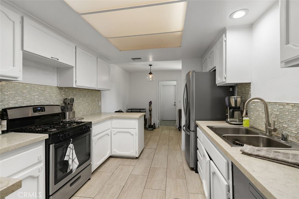 5082 Los Olivos Way Riverside, CA 92505 - Photo 11 of 36 a kitchen that has a sink stainless steel appliances a counter space and cabinets