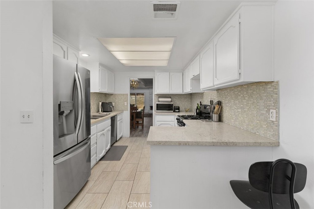 5082 Los Olivos Way Riverside, CA 92505 - Photo 15 of 36 a kitchen with stainless steel appliances granite countertop a refrigerator sink and cabinets