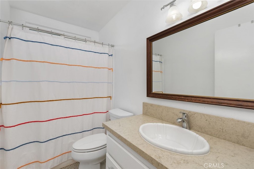 5082 Los Olivos Way Riverside, CA 92505 - Photo 22 of 36 a bathroom with a toilet a sink and mirror