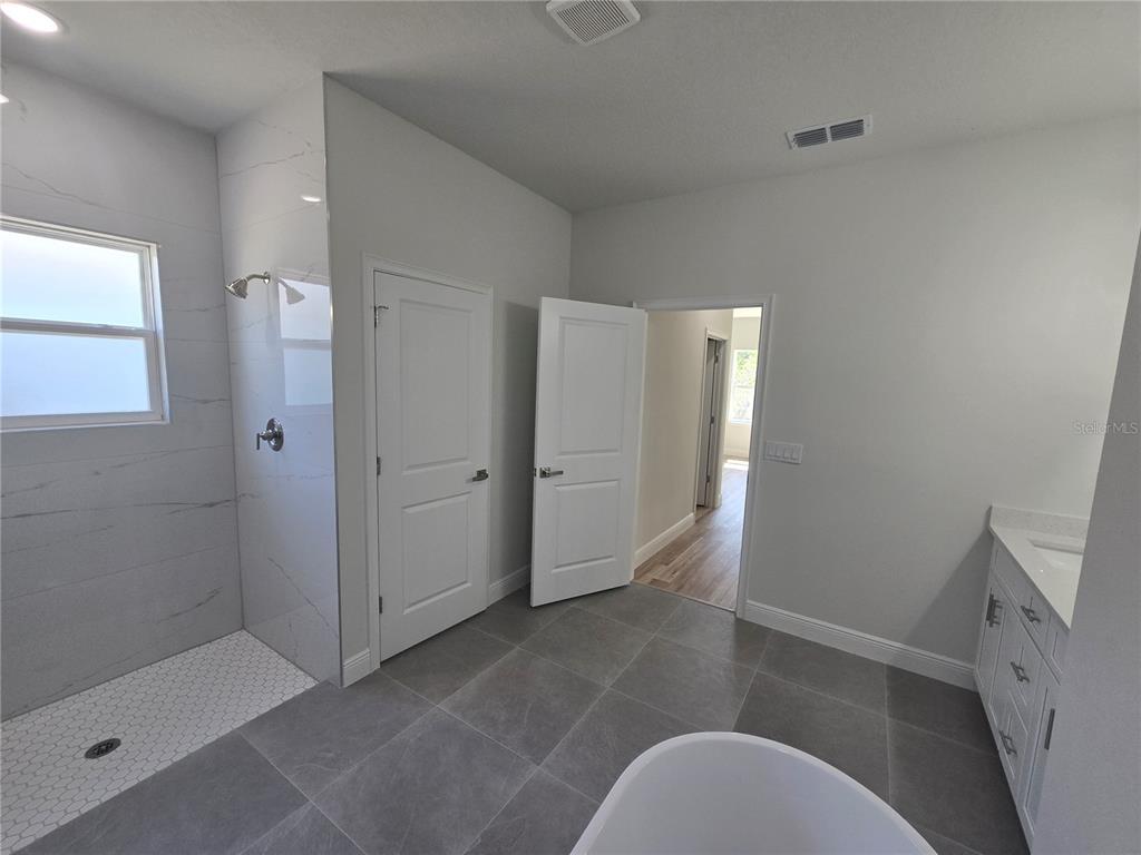 2644 Southwest 162nd Street Road Ocala, FL 34473 - Photo 25 of 47 a bathroom with a sink and glass door shower