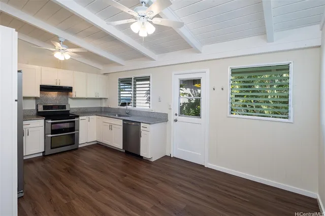 a kitchen with a sink cabinets stainless steel appliances and a window