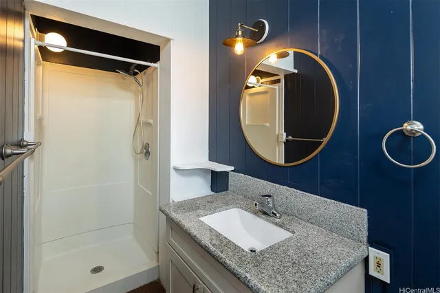 a bathroom with a granite countertop sink and a mirror