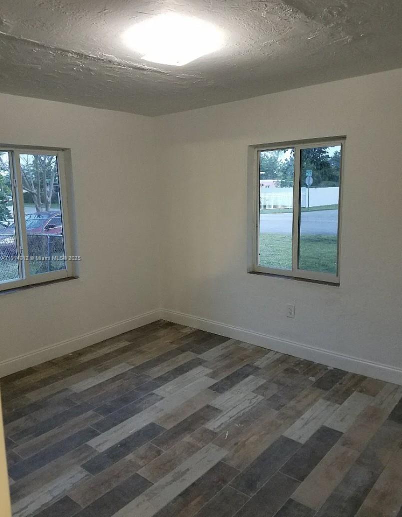 2125 Northwest 126th Street Miami, FL 33167 - Photo 5 of 6 an empty room with wooden floor and windows