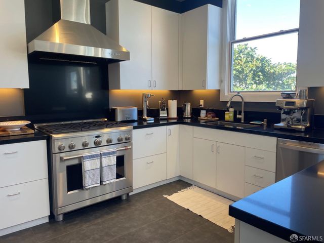 a kitchen with stainless steel appliances a stove a sink and a microwave