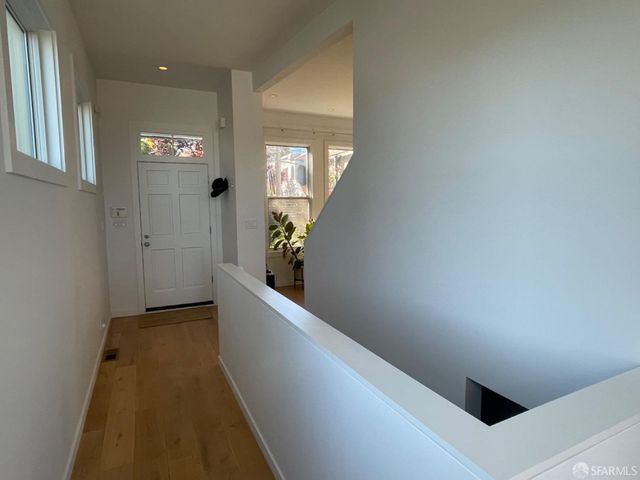 a view of entryway with wooden floor and stairs