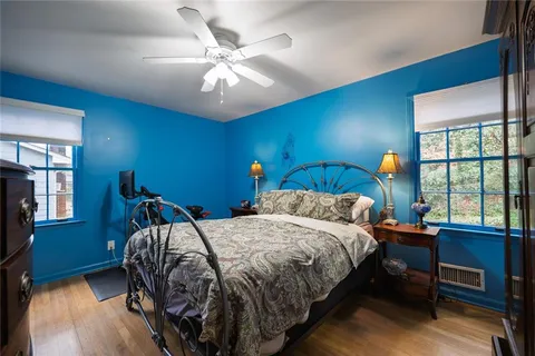 a bedroom with a bed a chandelier and a large window