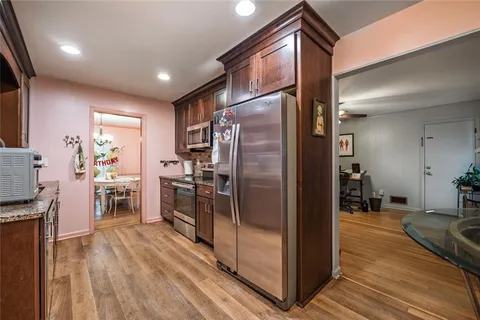 a kitchen with kitchen island a counter top space a sink stainless steel appliances and cabinets