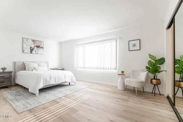 a bedroom with a bed and a potted plant